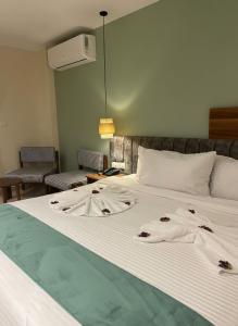 a large white bed with someones clothes on it at Boutique De Pirámides Nómadas in Cairo