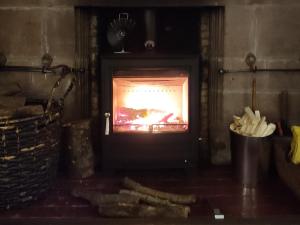 a fireplace with a fire in it in a room at Whitehall Pele Tower in Mealsgate