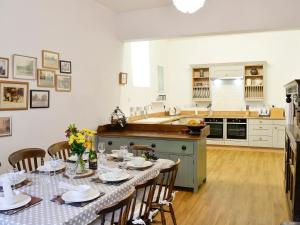 a kitchen with a table with plates and flowers on it at Whitehall Pele Tower in Mealsgate