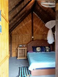 a bedroom with a bed in a thatched room at koh mook oyoy reggaebar bungalow in Ko Mook