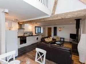 een woonkamer met een bank en een keuken bij Willow Barn - Fernhill Farm in Wootton Bridge