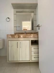 um banheiro com uma pia e um espelho em Apartamento de 2 quartos equipado em Imbituba sc em Imbituba