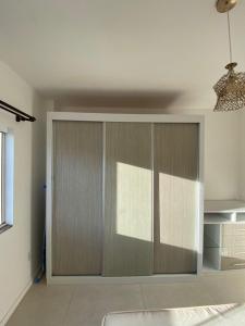 uma cozinha com armários de madeira num quarto em Apartamento de 2 quartos equipado em Imbituba sc em Imbituba mais 2 fotografias