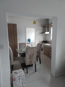 uma cozinha e sala de jantar com mesa e cadeiras em Apartamento de 2 quartos equipado em Imbituba sc em Imbituba