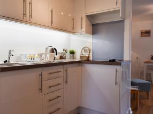 una cucina con mobili bianchi e un lavandino di Royal Views a Keswick