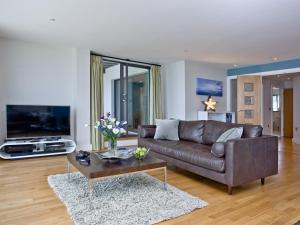 een woonkamer met een bruine bank en een salontafel bij The Penthouse Bay View in Westward Ho