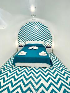 a bedroom with a blue bed and a checkered floor at La Casa del Capitano in Amalfi