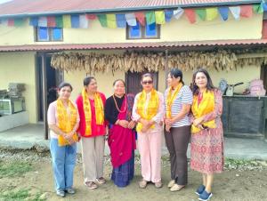a group of women standing in front of a house at Khasre Gurung Gaun Homestay in Nagarkot