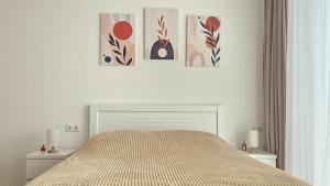 a bedroom with a bed with three pictures on the wall at Bakuriani Cozy Studio in Bakuriani