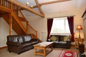 a living room with a leather couch and a table at Netherend in Threlkeld