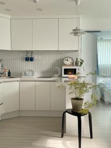 a kitchen with white cabinets and a table and a clock at LIKE Mangwon in Seoul