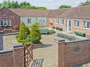 a house with a courtyard with trees and a fence at Mallard Cottage - E3751 in Leverton