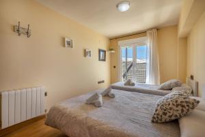 two beds in a room with a window at Alpine Sierra Nevada in Sierra Nevada