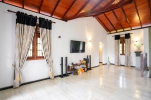 a large living room with black curtains and a flat screen tv at Villa Amora in Patuwata