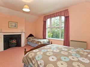 een slaapkamer met een bed en een open haard bij Bridge End - E1028 in Waxham