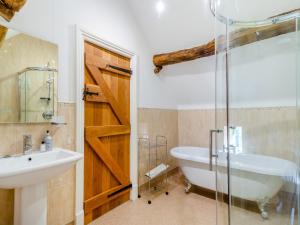 キャッスルトンにあるColtus Landsの浴槽、洗面台、シャワーを備えたバスルーム +6枚の写真