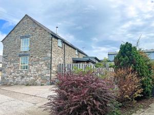 a stone house with a fence in front of it at Smithy Barn - Hw7592 in Bettws-yn-Rhôs +8 photos