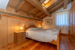 a bedroom with a bed and a wooden ceiling at Dreamful Cottage in Selva di Cadore