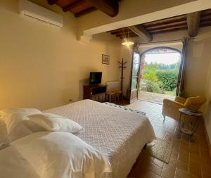 een slaapkamer met een bed en een groot raam bij Castel Brunello in Montalcino