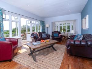 a living room with leather furniture and a table at Manorbier Boat House in Manorbier