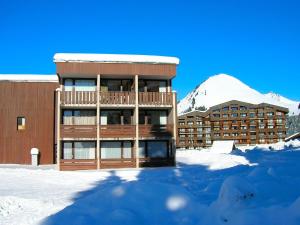 ein Gebäude mit Balkon im Schnee in der Unterkunft Studio charmant avec terrasse et parking au Praz de Lys - FR-1-815-19 in Le Praz de Lys