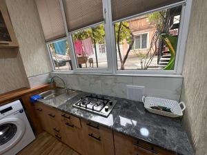 Una cocina con estufa, fregadero y ventana. en Tbilisi historical center, en Tiflis 3 fotos más