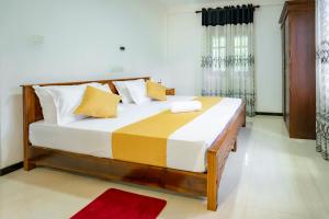 a bedroom with a large bed with yellow and white pillows at Villa Amora in Patuwata