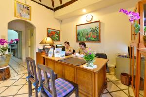 two people sitting at a reception desk in a room at Supatra Hua Hin Resort in Hua Hin