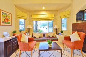 a living room with orange chairs and a couch at Supatra Hua Hin Resort in Hua Hin