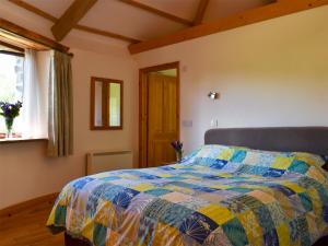 Saint EndellionにあるRound House - Uk12083のベッドルーム(カラフルなキルトのベッド付)
