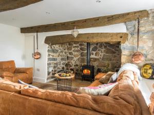 ein Wohnzimmer mit einem Sofa und einem Steinkamin in der Unterkunft Bwlchgroes in Dinas + 18 Fotos
