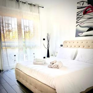 a bedroom with a large white bed with towels on it at Residenza stadio in Turin +17 photos