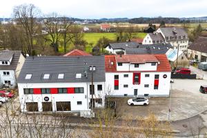 ein weißes Haus mit roten Fenstern und ein weißes Auto in der Unterkunft B&S Hotel in Weißenhorn
