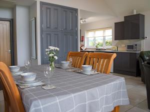 a dining room table with a blue table cloth and chairs at Bumble Lodge in Llynclys