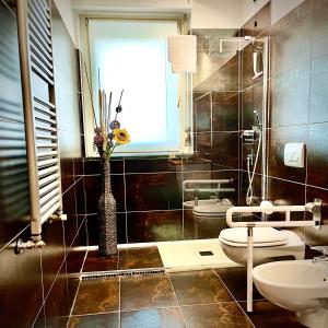 a bathroom with a toilet and a vase of flowers at Residenza stadio in Turin