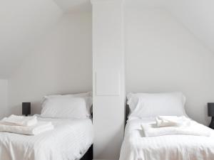 une chambre avec deux lits avec des draps blancs dans l'établissement Roe Cottage - Uk33490, à Hadleigh