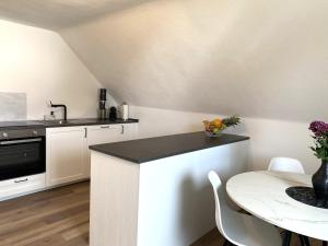 Una cocina con encimera, mesa y fregadero. en Modernes Wohlfühl-Apartment im Illertal, en Dettingen an der Iller