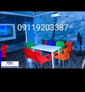 a table and chairs in a room with a sign at KOLLYPOPS Apartments in Otta