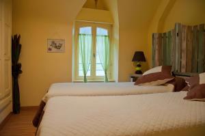 two beds in a room with a window at A L'abri in Saint-Nolff