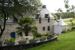 a stone house with plants in front of it at A L'abri in Saint-Nolff