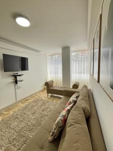 a living room with a couch and a flat screen tv at Unbeatable location in Medellín in Medellín