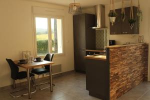 a kitchen with a small table and a table and chairs at Maison ROSAE Vinca  +26 photos