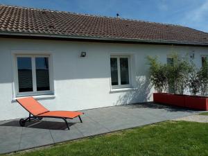 a orange chair sitting in front of a house at Maison ROSAE Vinca 