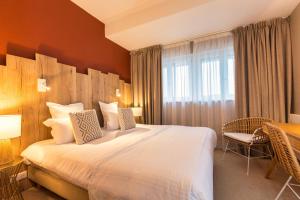 a hotel room with a large bed and a desk at Hôtel BO & MIA in La Baule