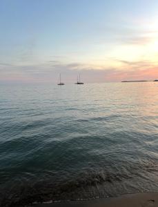 シェンジンにあるApartament shengjin Bekoのビーチでの夕日の水上ボート2隻