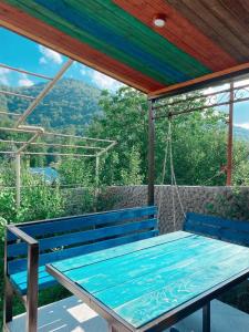 a blue bench on a porch with a swing at Green Garden Dilijan in Dilijan