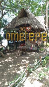 a hut with a sign that says cheer up at la chiponga beach hostel in Altagracia