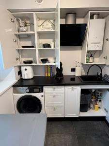 a white kitchen with a washing machine and a sink at Flat In the heart of Kaunas city center in Kaunas