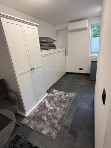 a kitchen with white cabinets and a tile floor at Flat In the heart of Kaunas city center in Kaunas