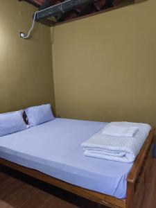 La Bella Hotels and Resorts في بوروليا: سرير عليه شراشف بيضاء ومناشف +صورتان